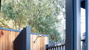 A wooden gate with a metal handle, leading to a wooden deck.