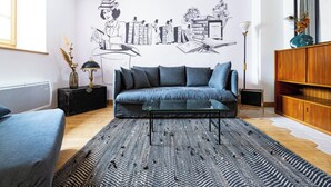 Un salon moderne avec un canapé, une table basse et un tapis à motifs.