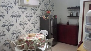 A small kitchen with a refrigerator, a table with chairs, and a water dispenser. - 2 bedroom apartment - Manga Cartagena Colombia (Cartagena de Indias)