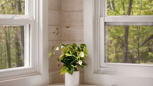 Ein Zimmer mit Holzausstattung, einem weißen Heizkörper, einem Tisch und einer hängenden Leuchte.