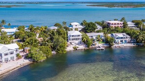 A coastal resort with multiple beachfront villas, clear waters, and lush greenery.