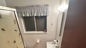 Un baño pequeño con inodoro, lavabo y ventana.