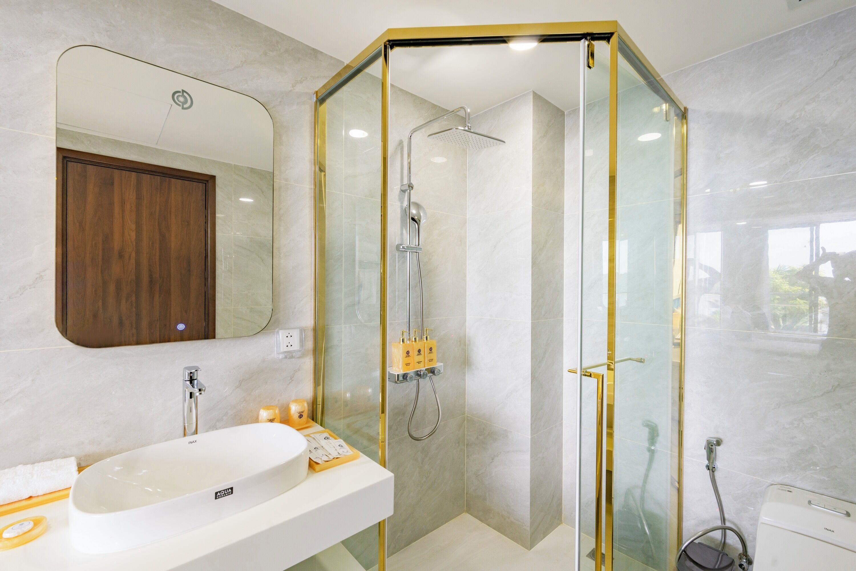 Une salle de bain moderne avec une douche à parois de verre, un lavabo blanc et un meuble en bois.