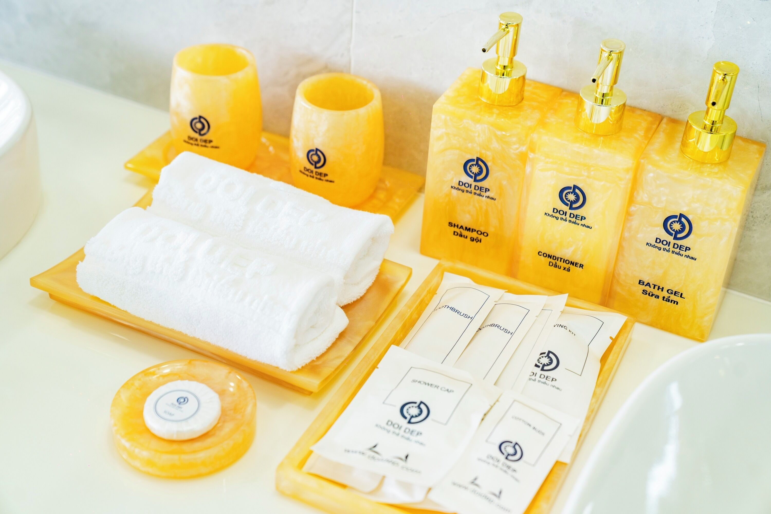 A bathroom with a towel, bottles of shampoo, conditioner, and bath gel, along with a toothbrush and toothpaste.