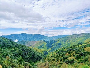 A mountainous landscape with lush green valleys and a clear sky. - Anurag Hotel Chakrata  (Kalsi)