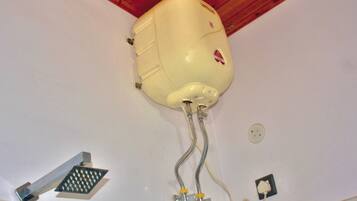 A ceiling-mounted water heater with exposed pipes and a control valve.