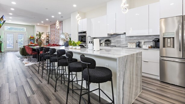 A modern kitchen with white cabinets, a marble countertop, and stainless steel appliances. - Spacious 4-bedroom house in lovely Dallas W/Game room & Spa (Dallas)