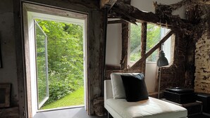 Une chambre avec un lit, une fenêtre et une vue sur la verdure.