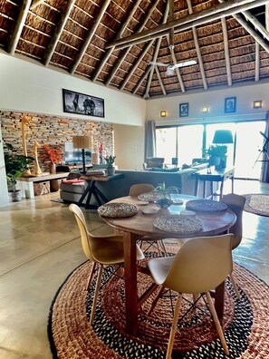 A dining area with a round table, chairs, and woven placemats.