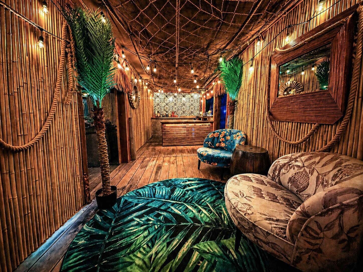 A room with a wooden floor, a sofa, a chair, and a small table.