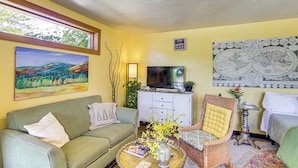 A living room with a sofa, armchair, coffee table, and a TV. - Walk to Dtwn Livingston: Studio w/ Mtn Views! (Livingston)