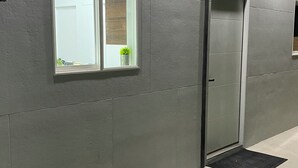 Un ascensor moderno con acabado metálico y un pequeño ventanal en la parte superior.