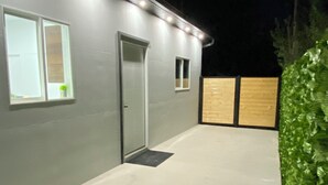 Un edificio moderno con fachada gris, una puerta y un ventanal pequeño.
