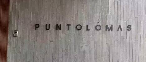 Un mur sur lequel est inscrit le texte « PUNTOLÔMAS » en grandes lettres.