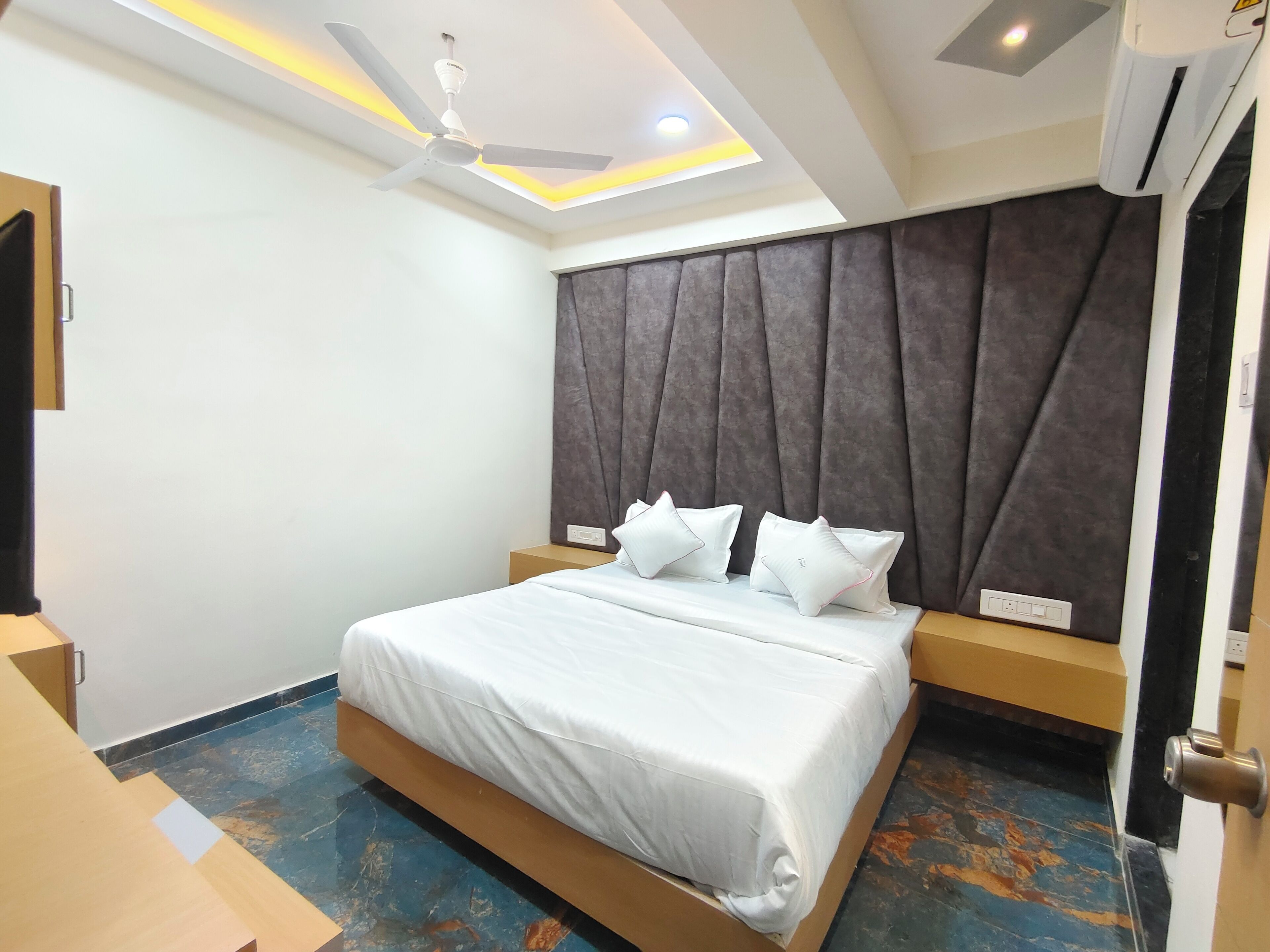 Ein modernes Hotelzimmer mit Bett, Deckenventilator und großem Fenster.