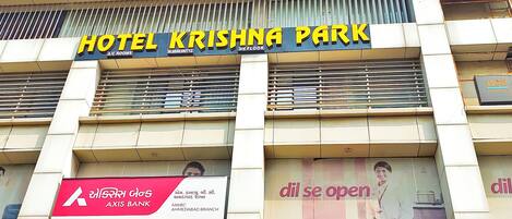 A building with the sign "HOTEL KRISHNA PARK" and "AXIS BANK" on the facade.