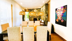 Un comedor con pared de piedra, chimenea y un cuadro en la pared.
