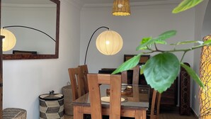A dining area with a wooden table, chairs, and a hanging light fixture. - MAISON ART COLLECTION (Essaouira)