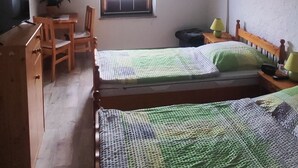 A room with two beds, a desk, a chair, a television, and a window. - Quiet vacation apartment in Thierstein in the Fichtelgebirge (Thierstein)