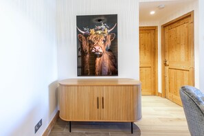Een modern interieur met een houten kast, een lijstwerk met afbeelding van een stier en houten deuren.