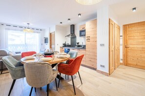 Een moderne keuken met houten kastjes, een ingebouwde magnetron en een centraal eiland met zitplaatsen.