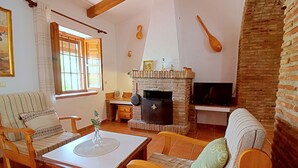 Een gezellige woonkamer met een open haard, houten meubels en een televisie.
