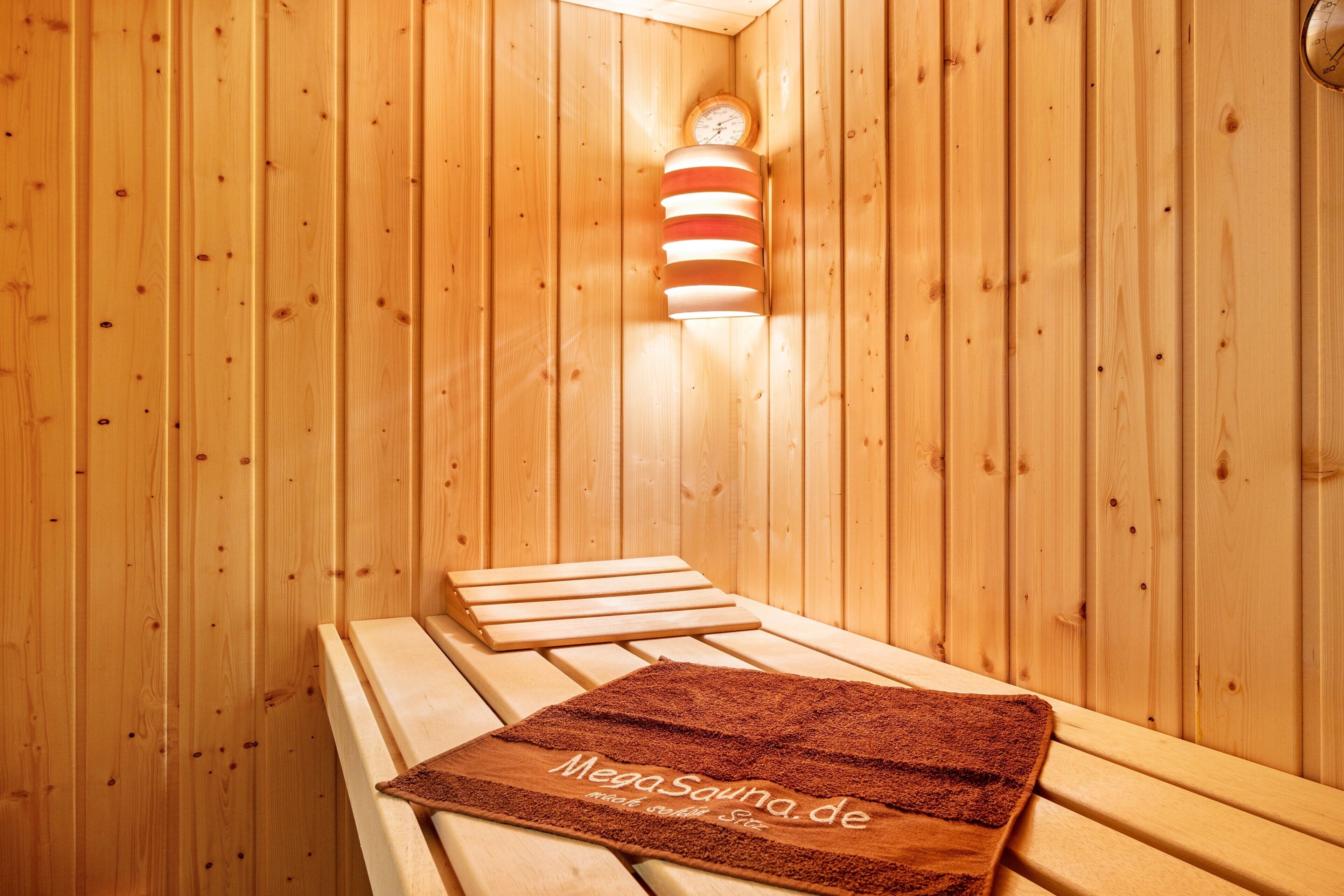 Una sauna de madera con bancos y una toalla.