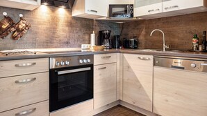 A modern kitchen with a built-in oven, a coffee maker, and a microwave.