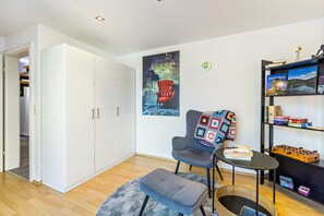A modern living room with a sofa, armchair, ottoman, and a foosball table. - Apartment 'My Cocoon' with Private Terrace and Wi-Fi (Lüdenscheid)