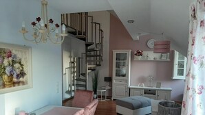 A modern interior with a staircase, dining area, and a cozy seating space.