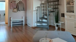 A modern interior with a spiral staircase, a white cabinet, and a dining table with a decorative item.