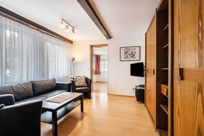 Un salon moderne avec un canapé, une table basse et un téléviseur.