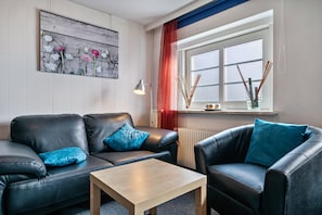 A modern living room with a sofa, armchair, and coffee table.