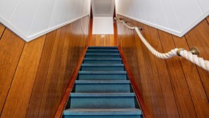 A wooden staircase with a blue carpet, white walls, and a rope handrail. - Hus achtern Diek Cuxhaven Apartment No. 10 (Cuxhaven)