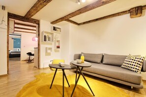 A modern living room with a sofa, a small round table, and a yellow rug. - Holiday Apartment 'Constance' with Wi-Fi (Konstanz)