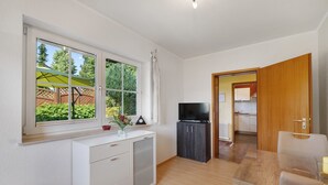 A room with a window, a TV, a desk, and a chair. - Apartment 'Waltraud' with Shared Terrace, Shared Garden and Wi-Fi (Meßstetten)