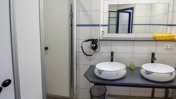 Een badkamer met twee wastafels, een spiegel en een handdoekhouder.