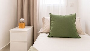 A bedroom with a bed, a nightstand, and a lamp.