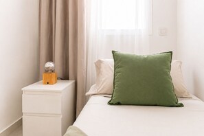 Un dormitorio con una cama, una mesita de noche y una lámpara.