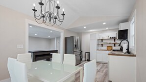 Una cocina moderna con armarios blancos, un refrigerador de acero inoxidable y un horno empotrado.
