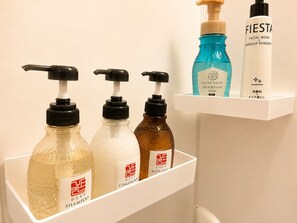 A bathroom shelf with various toiletries including shampoo, body soap, facial wash, and makeup remover. - MAJA HOTEL KYOTO (Kyoto)