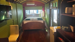 A cozy room with a bed, a chair, a small table, and a window with a view. - Stylish Studio on South terrace. 2 Minute walk to the beach. (South Fremantle)
