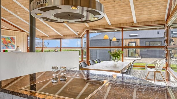 Una cocina moderna con una isla central, ventanas amplias y vistas al exterior.