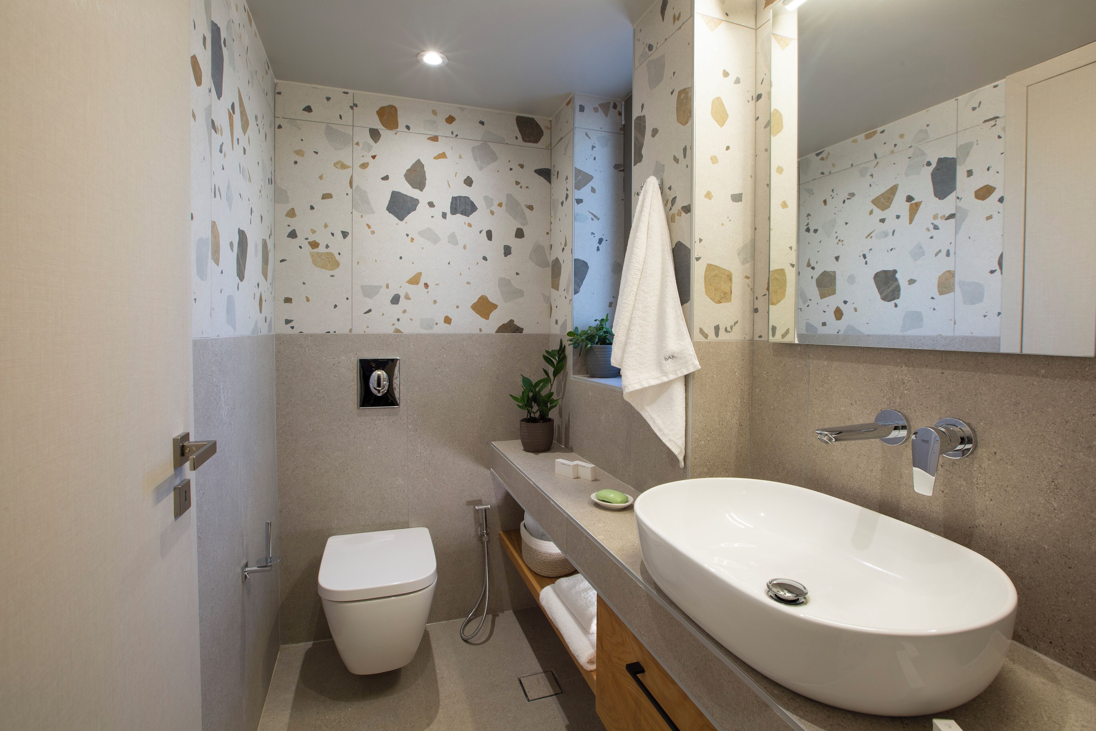 A modern bathroom with a white sink, a toilet, and a shower.