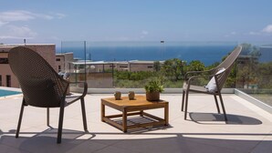 A balcony with two chairs, a small table, and a potted plant. - Villa Virgo Ammoussa Lefkada (Lefkada)