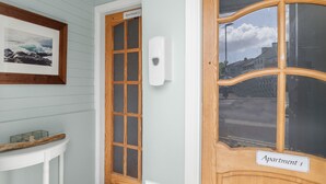 A wooden door with a frosted glass panel and a sign indicating 'Apartment 1'.