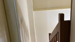 Un escalier avec une rampe en bois et un mur blanc.