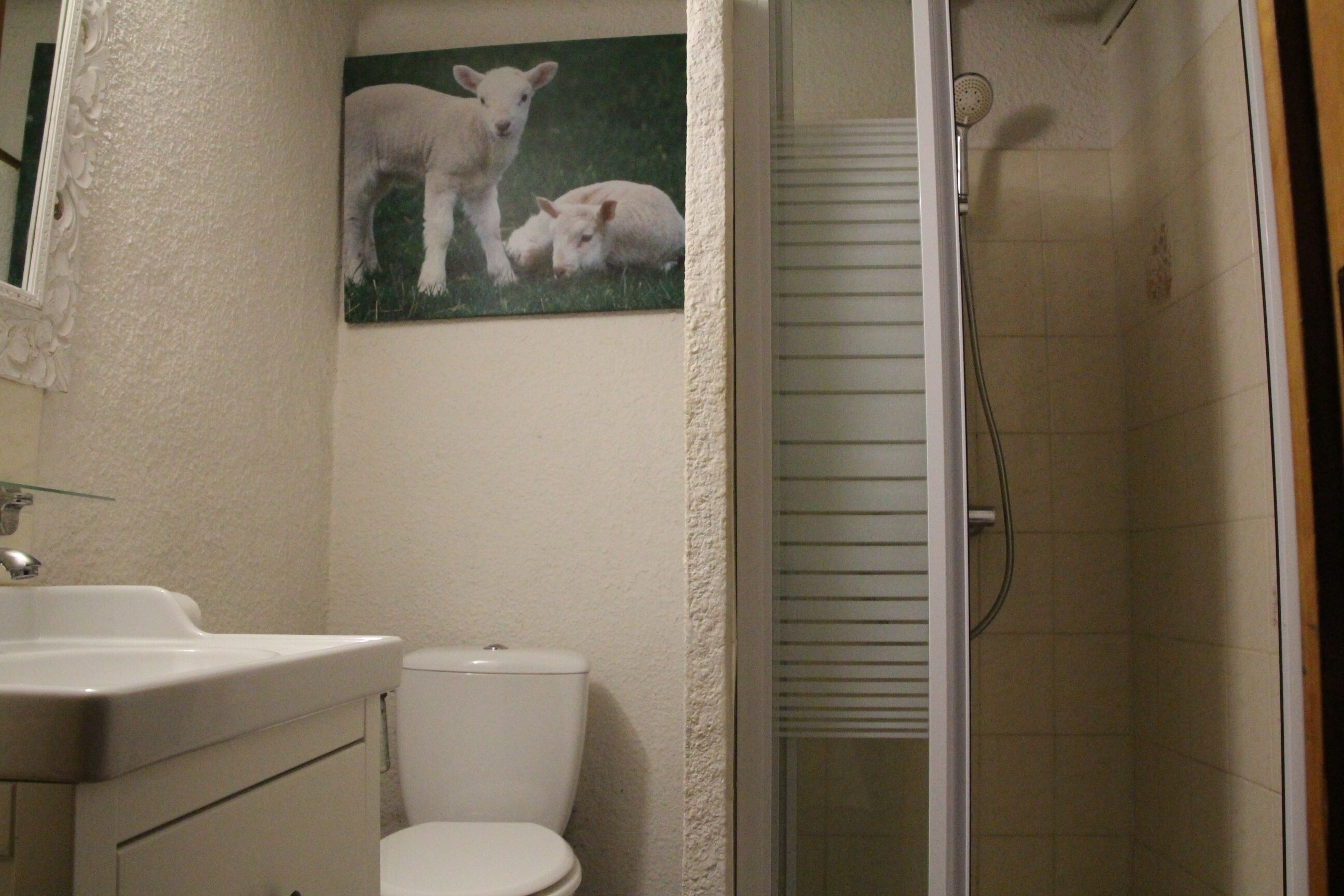 A bathroom with a toilet, sink, and shower.