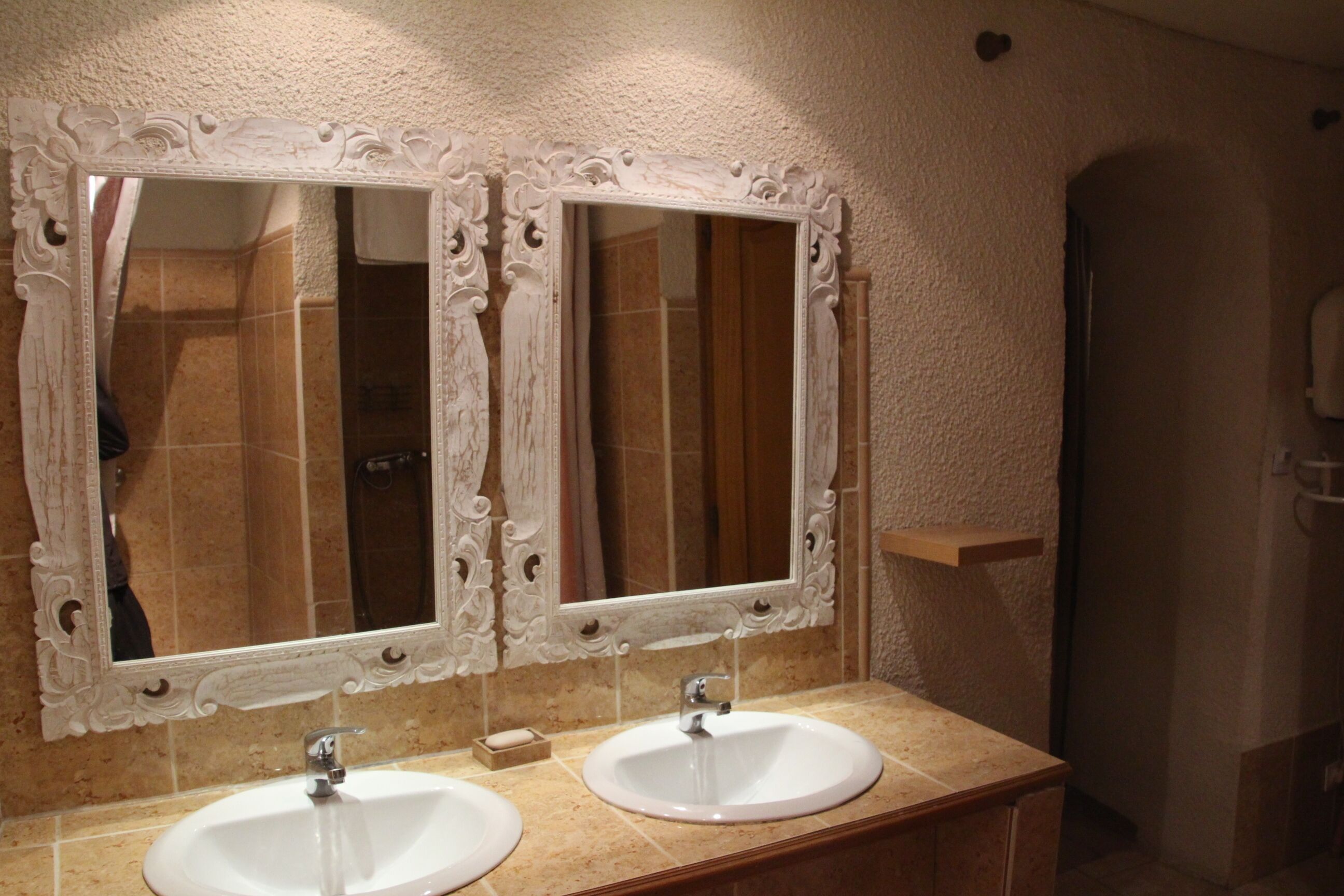 A bathroom with two sinks, each with a mirror above.