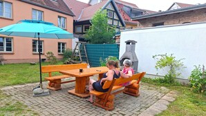 A patio with wooden furniture, a table, and a bench. - Ferienwohnung Kogge im Zentrum von Röbel (Röbel)